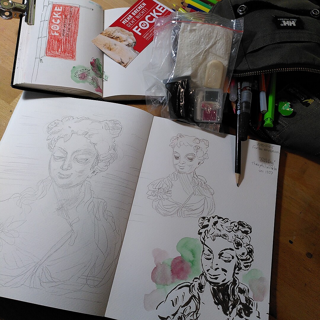 A photo of 2 sketchbooks with drawings, drawing/painting materials, and a museum ticket