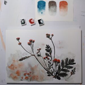 A photo of a watercolour painting of flowers, with watercolour half-pans and a paper scrap with swatches