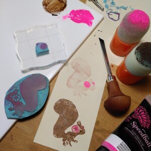 A photo of 2 stamp blocks of a squirrel with earmuffs, and various materials